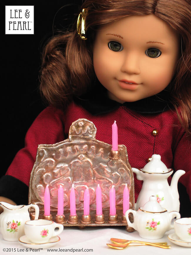 Happy Chanukah from Lee & Pearl! Make your American Girl Rebecca Rubin her own doll-scale circa 1900 traditional Chanukah Menorah (Chanukiya) using a dollar store baking sheet, some plastic beads — and our downloadable template, video tutorial and detailed newsletter directions.