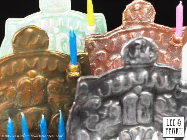 Happy Chanukah from Lee & Pearl! Make your 18 inch dolls their very own pressed metal Chanukah Menorah (Chanukiya) using a dollar store cookie sheet, cardboard, glue, plastic beads, a knitting needle, metallic paints and the techniques in our easy VIDEO TUTORIAL.