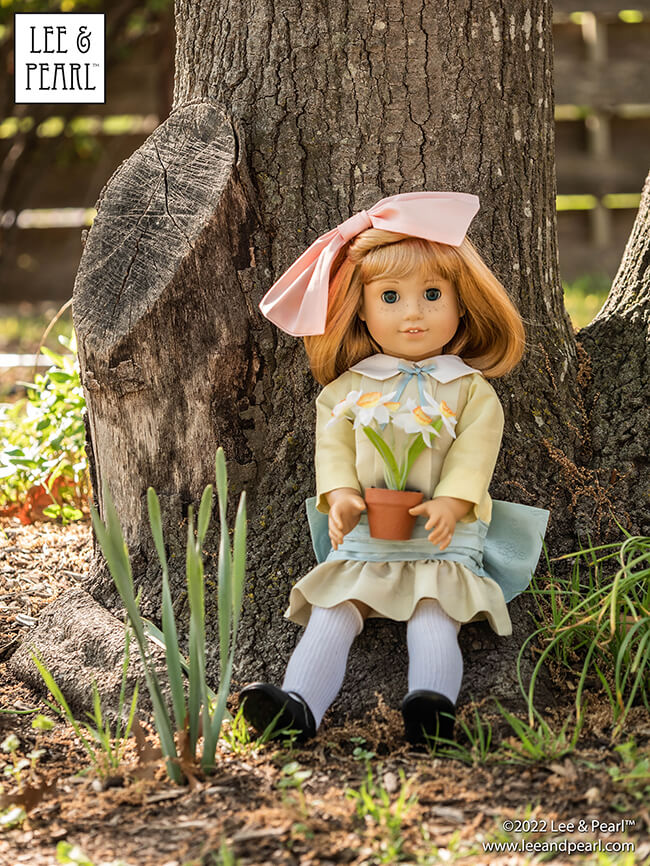 Happy Easter from Lee & Pearl! In this holiday pictorial, join our American Girl® doll Nellie as she explores a hidden garden, dressed in a lovely silk dress embellished with ribbons and bows, accompanied by seasonal props from our FREE tutorial and printable collection and the craft store floral and spring decor aisles.